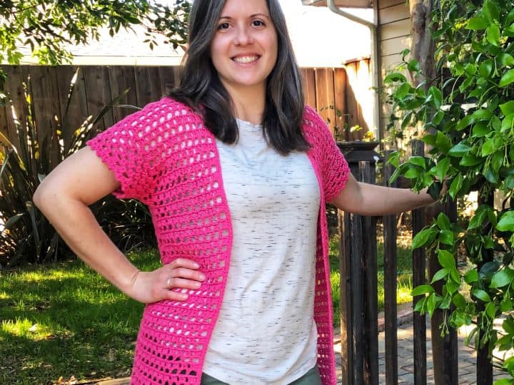 Woman smiling in pink crochet summer cardigan free pattern.