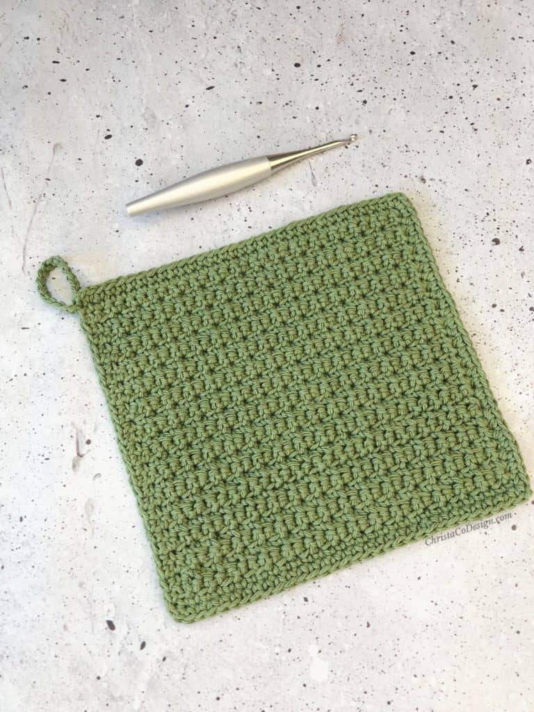 Silve crochet hook and kitchen dishcloth in green.