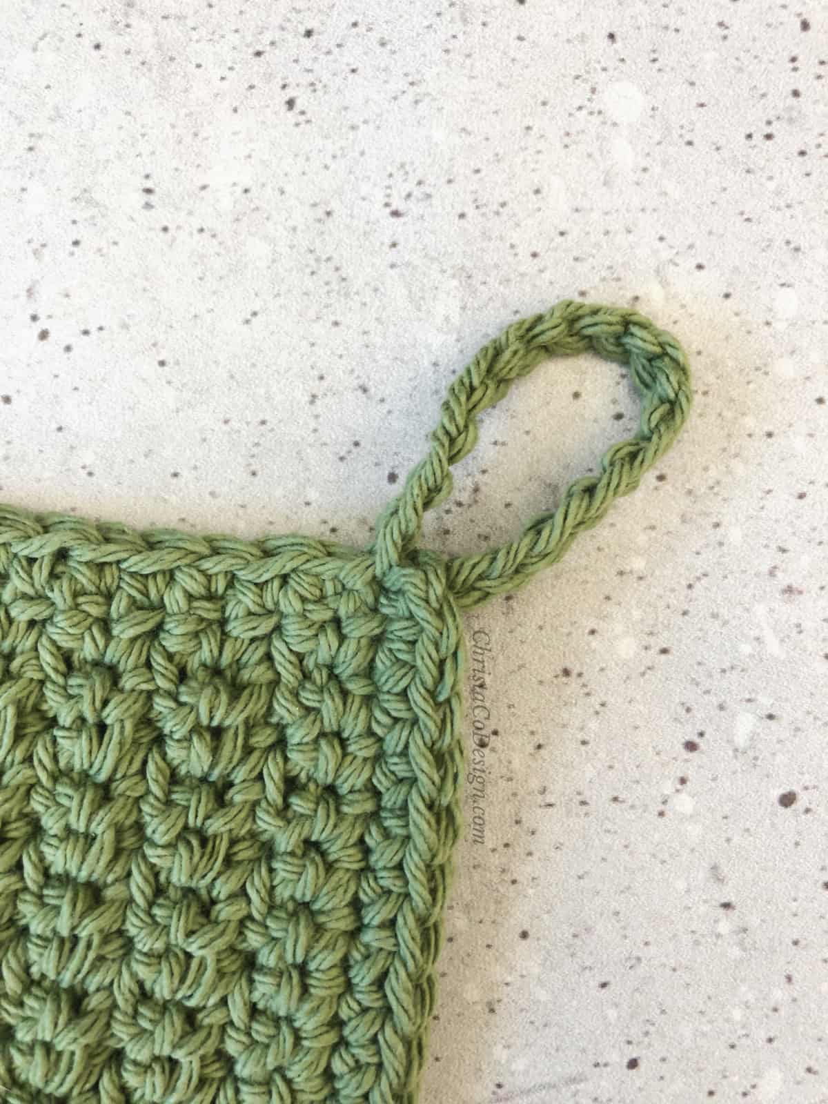 Close up of hanging loop for dishcloth.