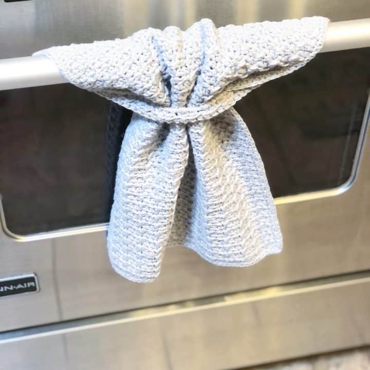 Stainless steel oven with crochet hand towel hanging.