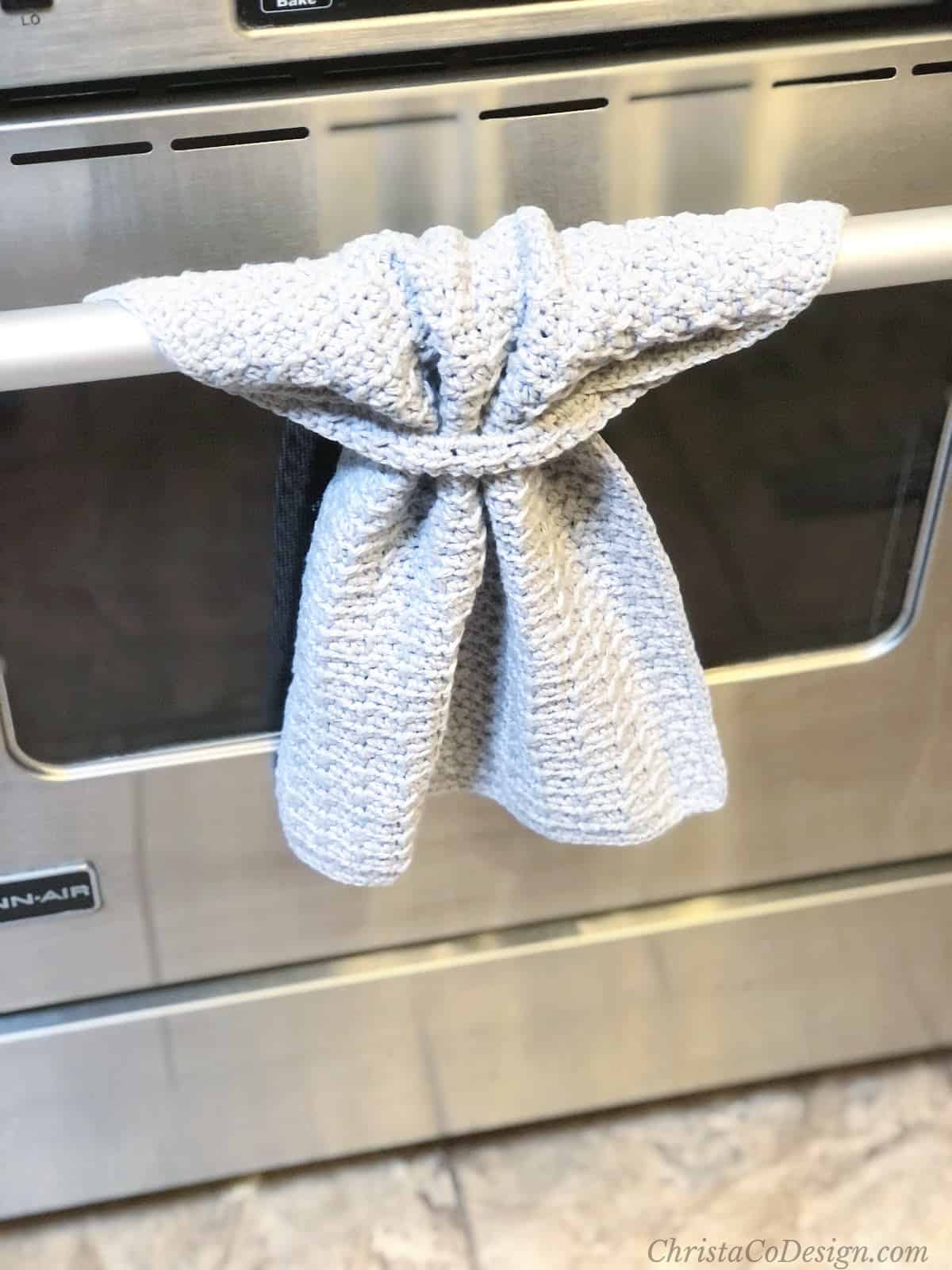 Stainless steel oven with crochet hand towel hanging.