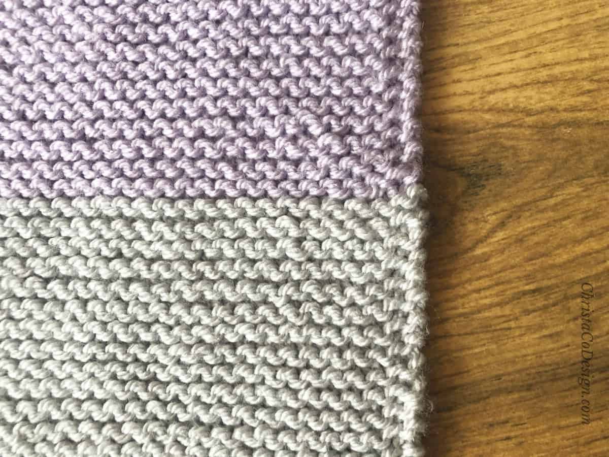 Purple and grey striped blanket with slip one edge.