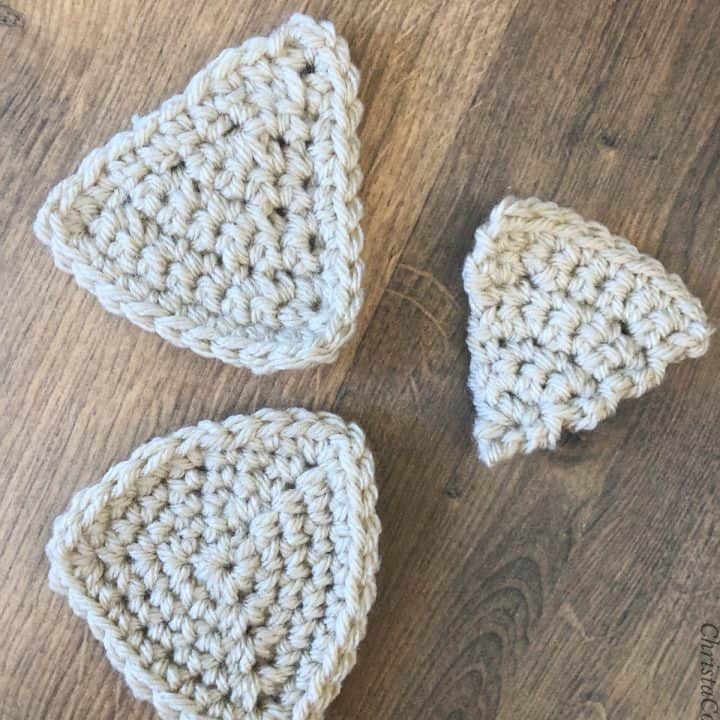 Three crochet triangles in beige yarn.