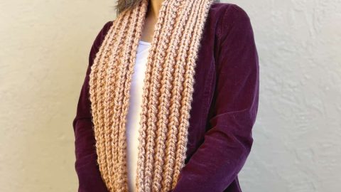 Woman in easy knit pocket scarf in warm brown.