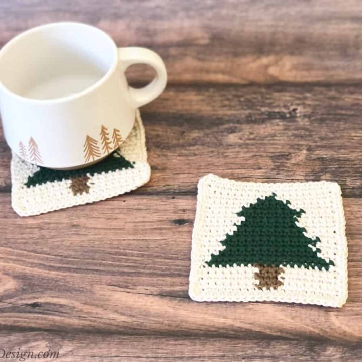 Crochet Christmas tree coaster and mug on wood table.