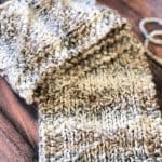 Knit scarf with stockinette, seed stitch and diamond purls.