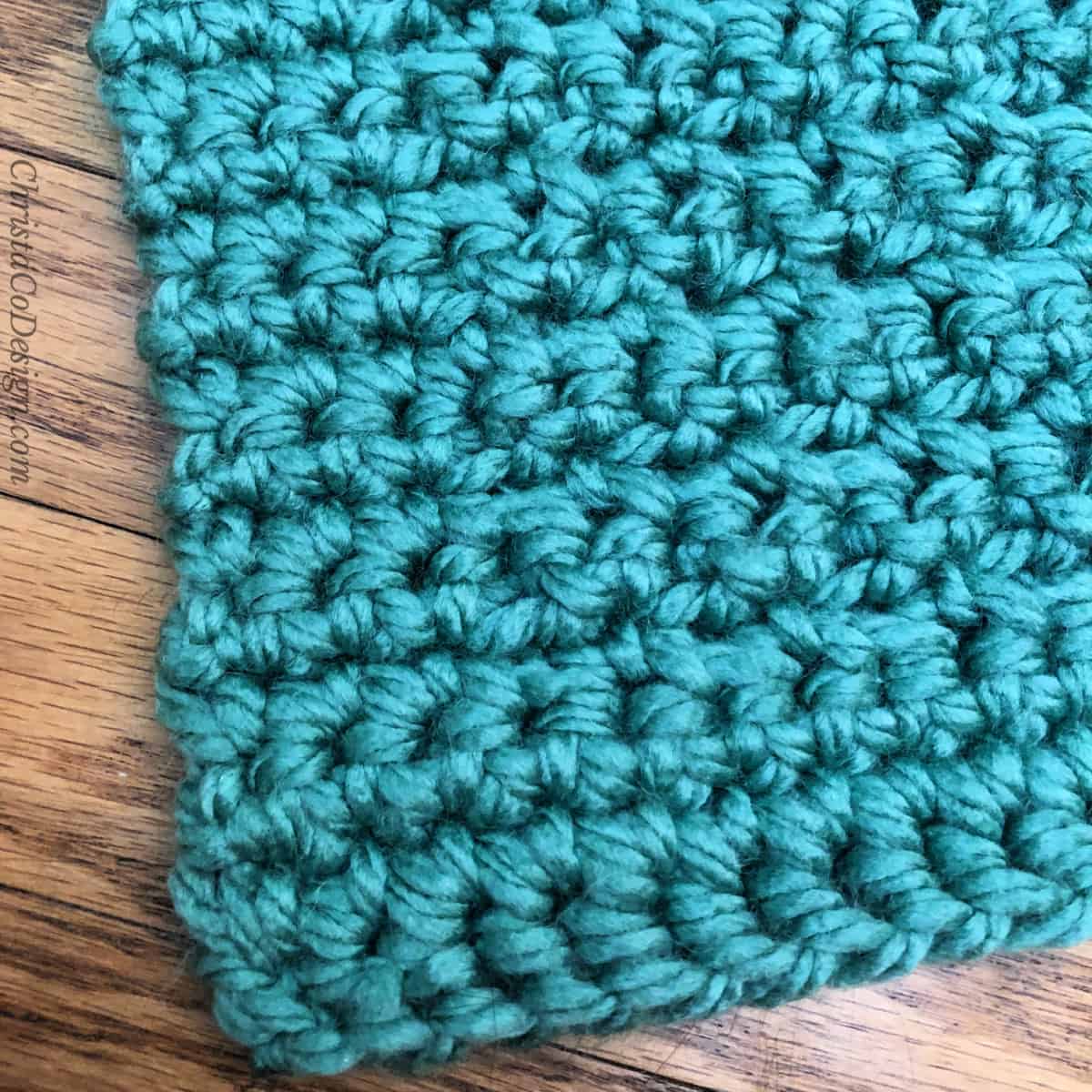 Close up of border edge in regular single crochet on blanket in green.
