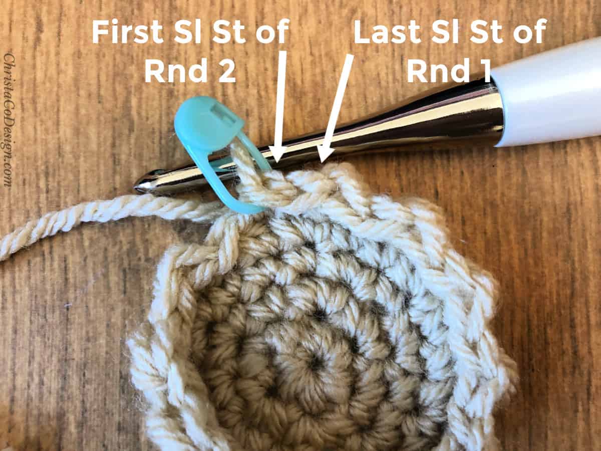 First sl st and last sl st of round labeled with white arrows on crochet basket side.