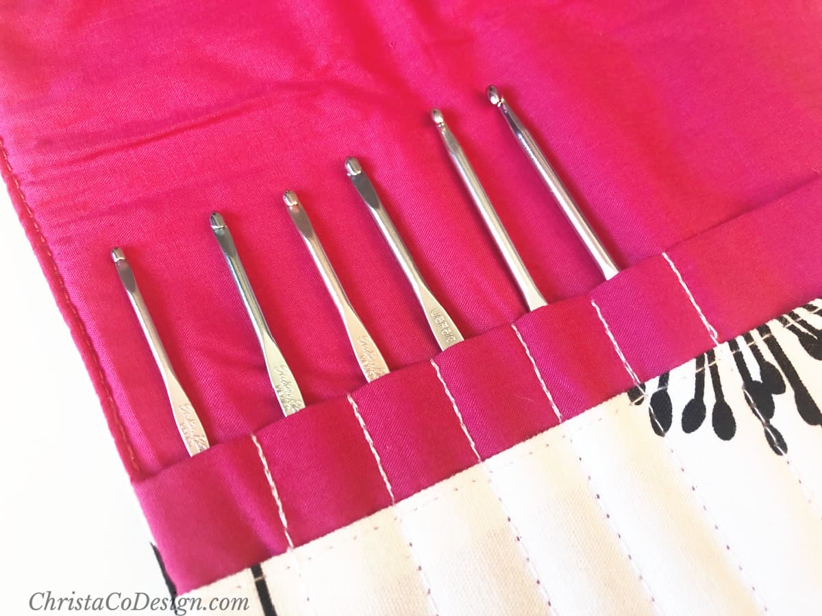 Several metal crochet hooks in pink pouch.