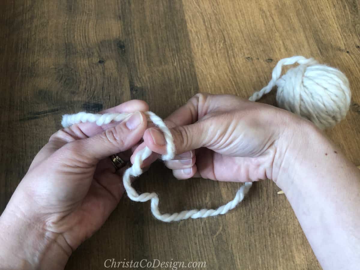 Grab yarn with two fingers through the loop.