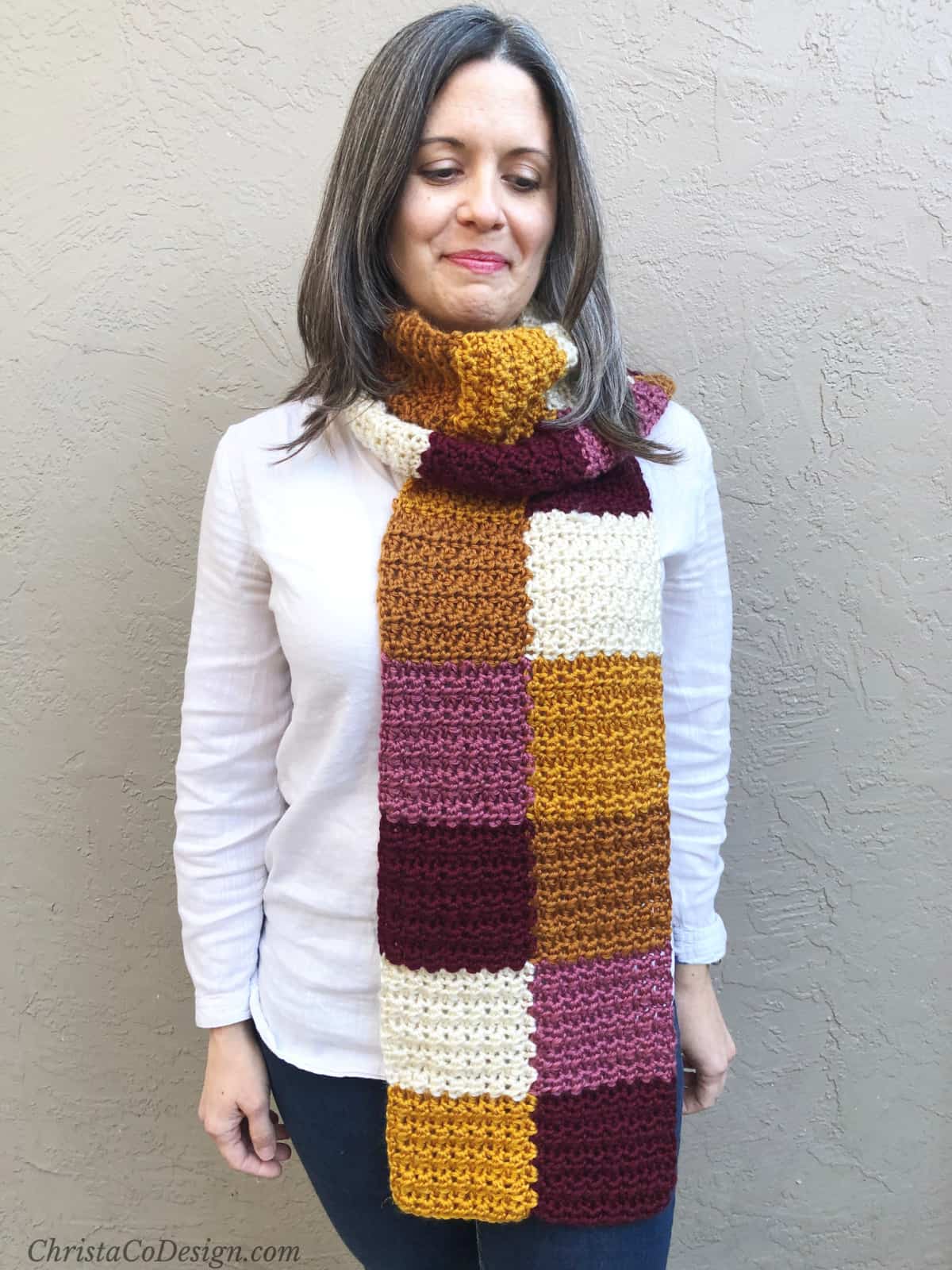 Autumn colored crochet scarf wrapped once around woman's neck.