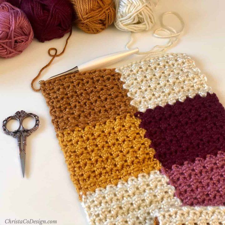 Crochet scarf of varying autumn colors in progress.