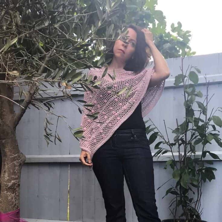 Woman outside with lacy pink shawl draped on shoulders.