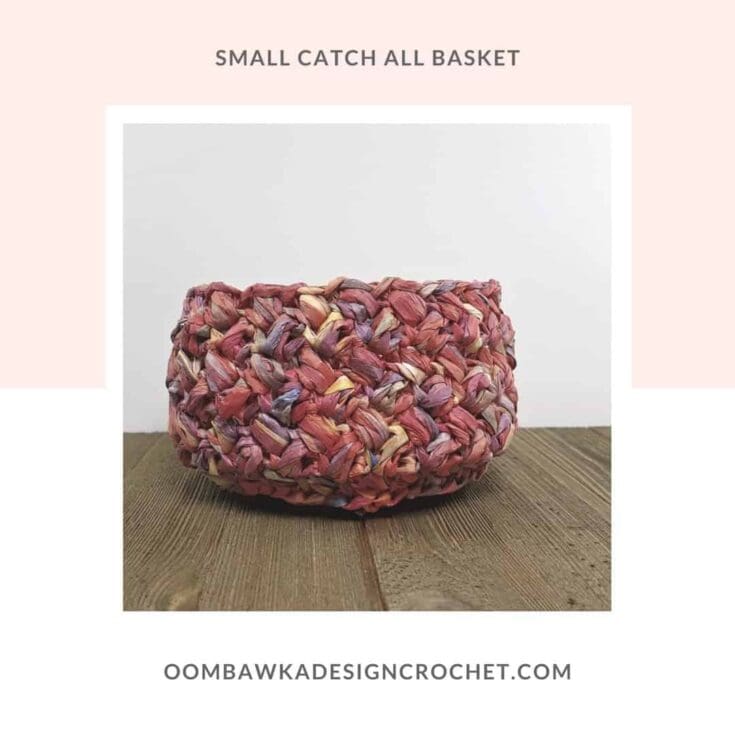 Small textured crochet basket in dark pink yarn with flecks.