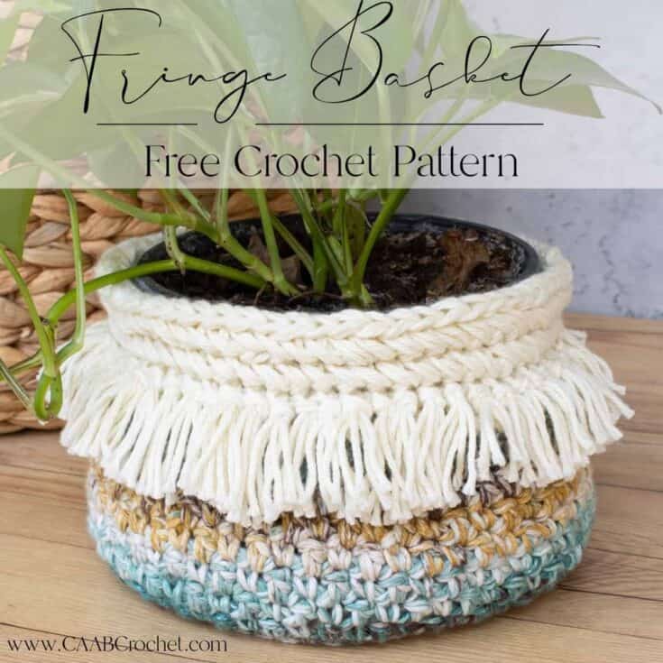 Blue and beige crochet basket with white fringe.