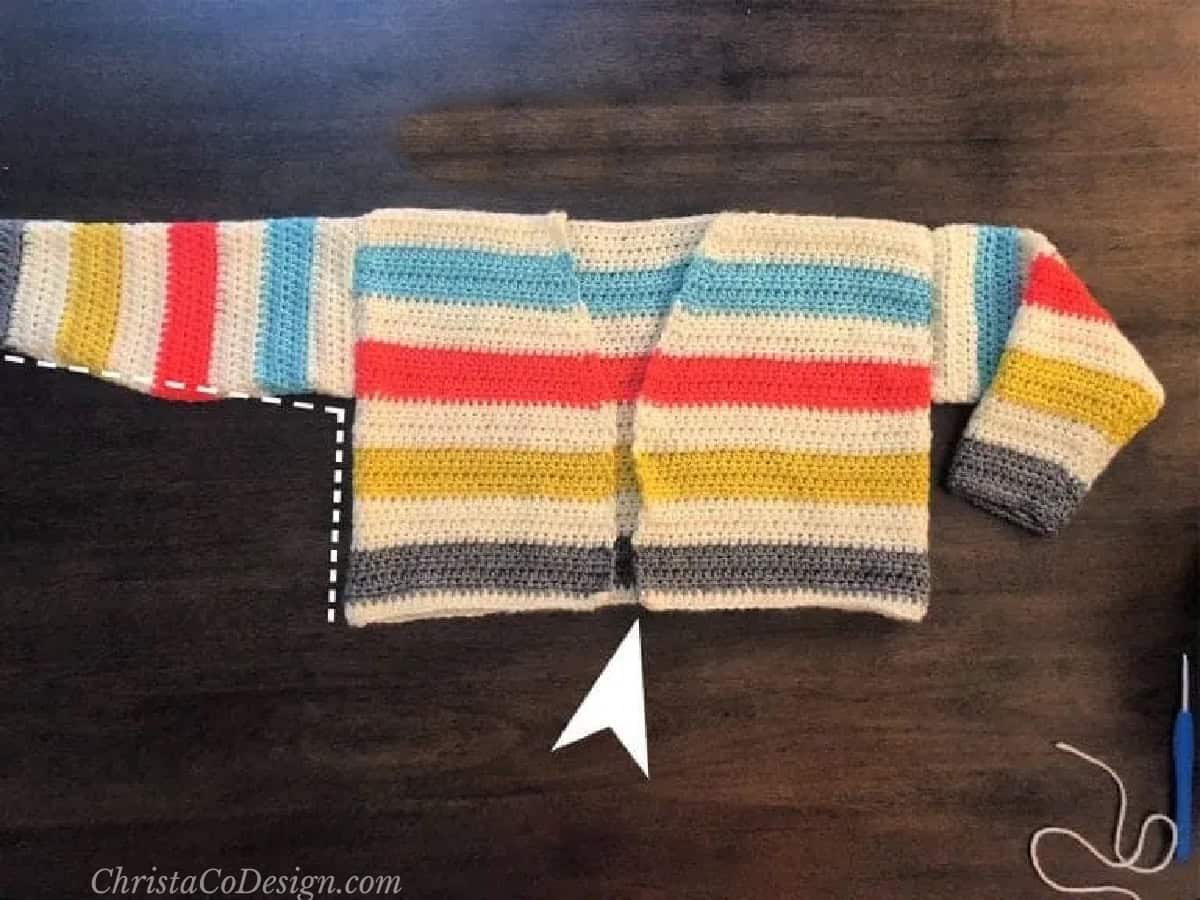 Crochet sweater with blue, coral, yellow and grey stripes pieced together.