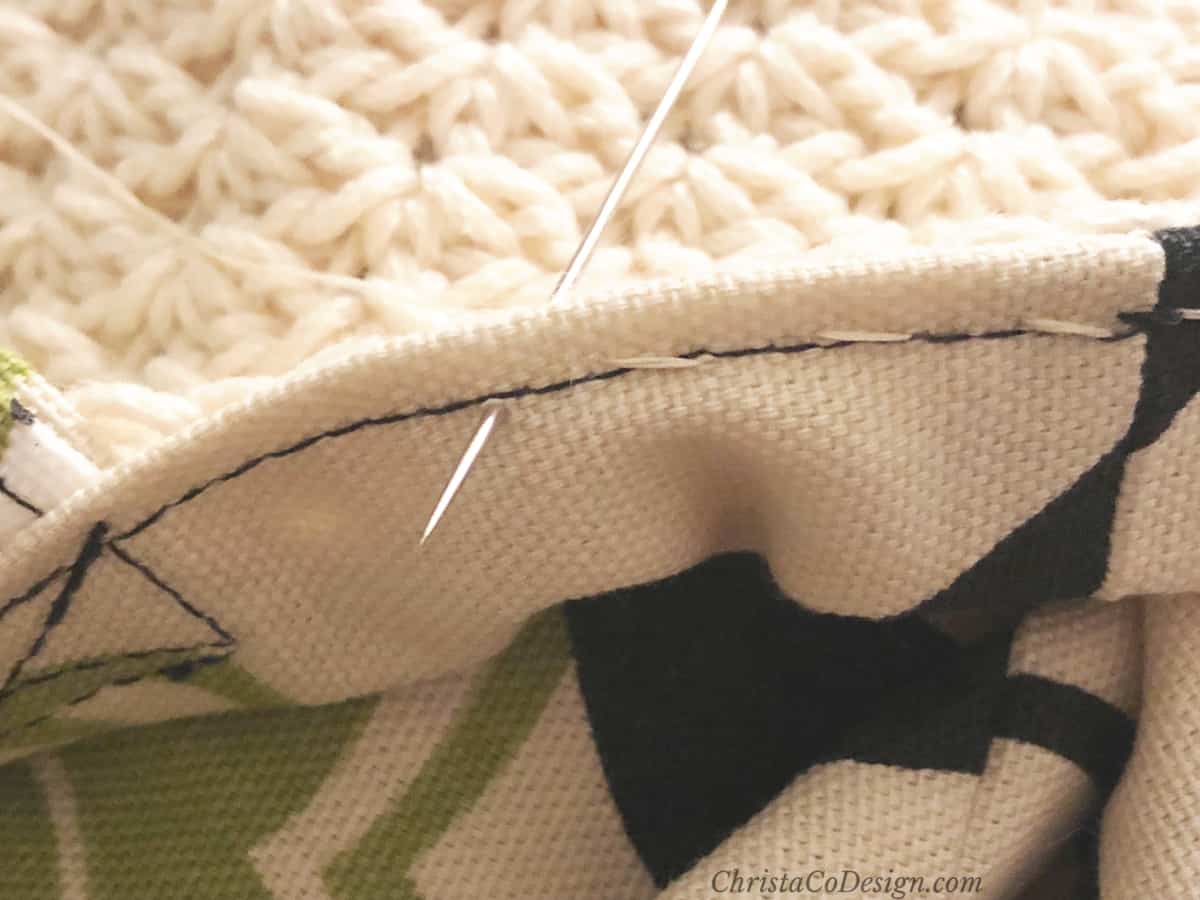 Hand sew along machine stitch hem to secure lining to bag.
