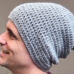 Close up of grey slouch hat on smiling man.