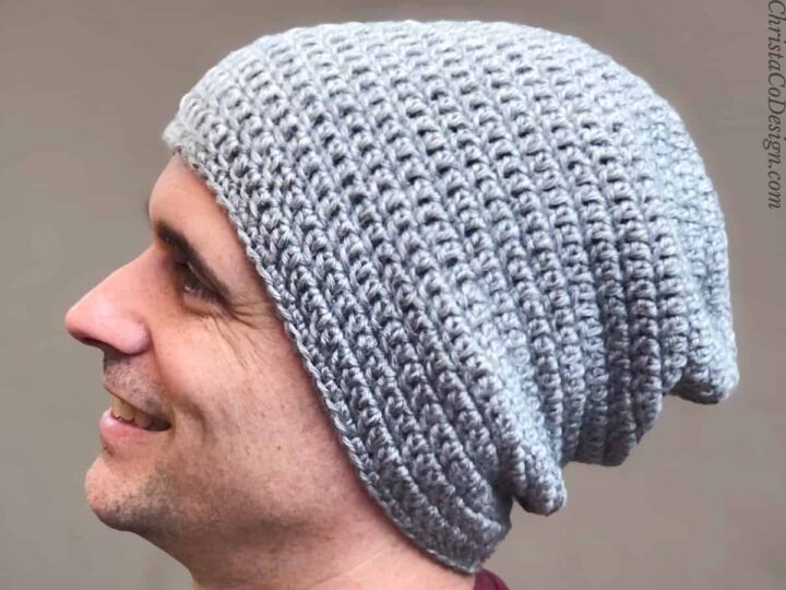 Close up of grey slouch hat on smiling man.