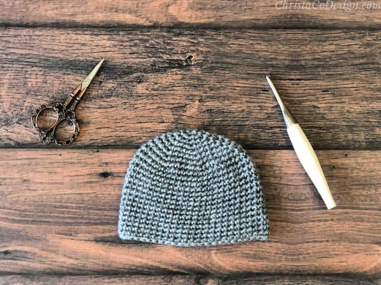 Grey crochet hat on table.