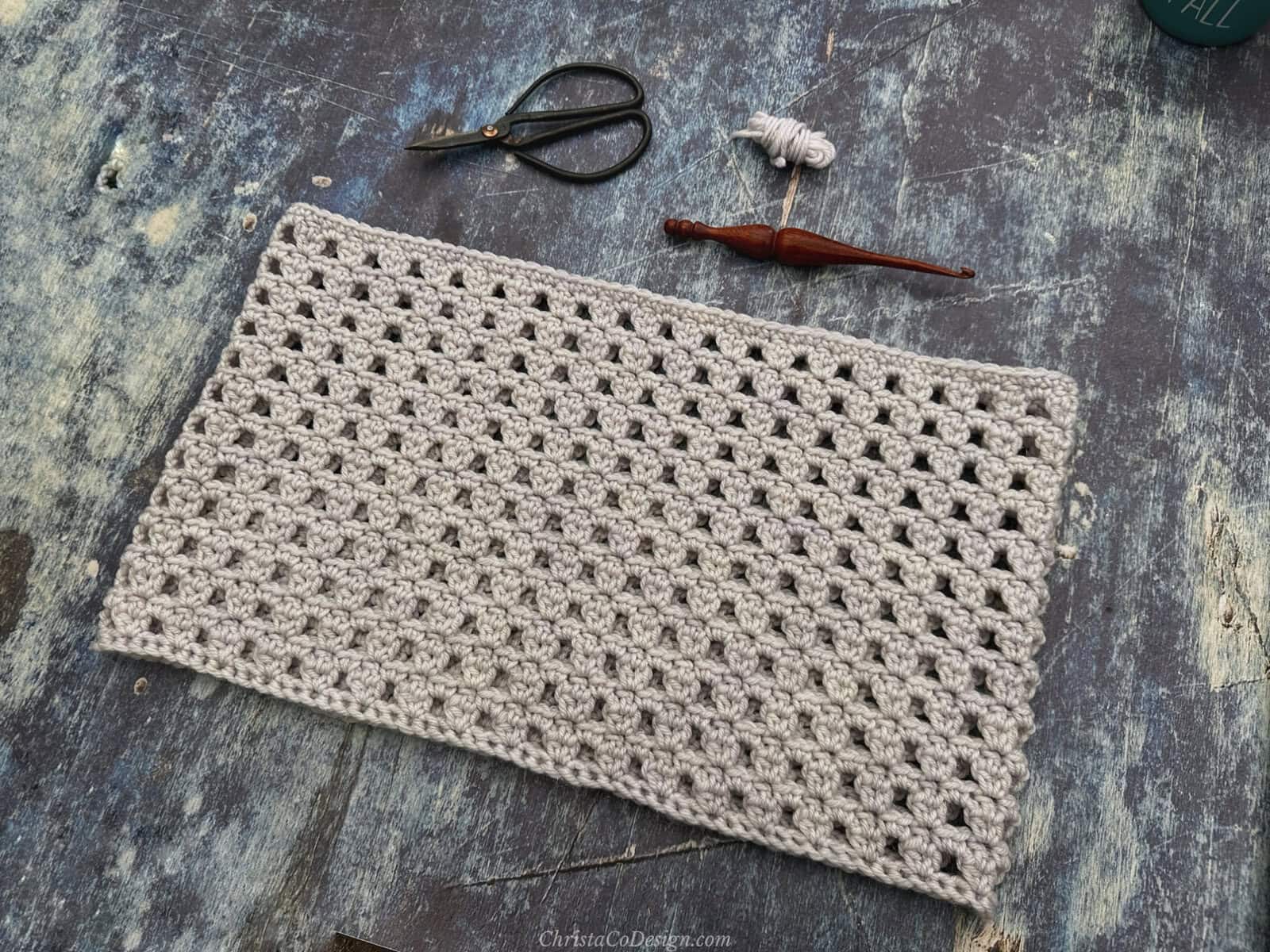 White crochet cowl on blue background.