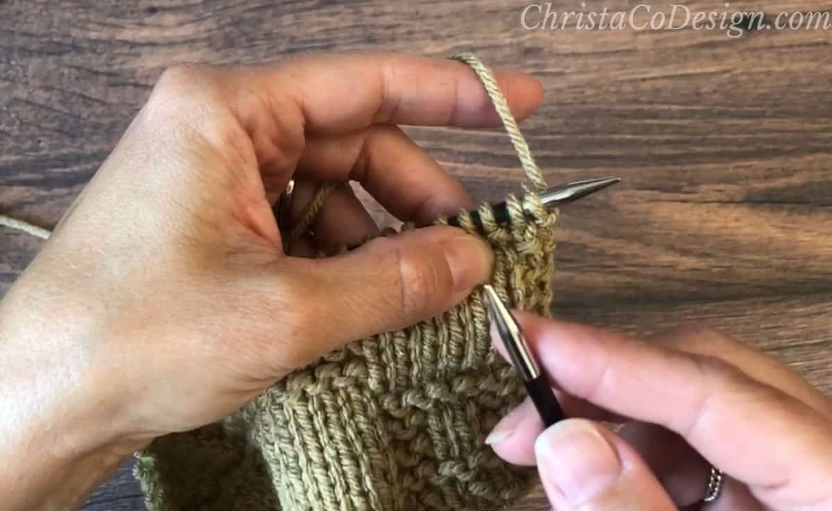 Hands with knitting ready to bind off.