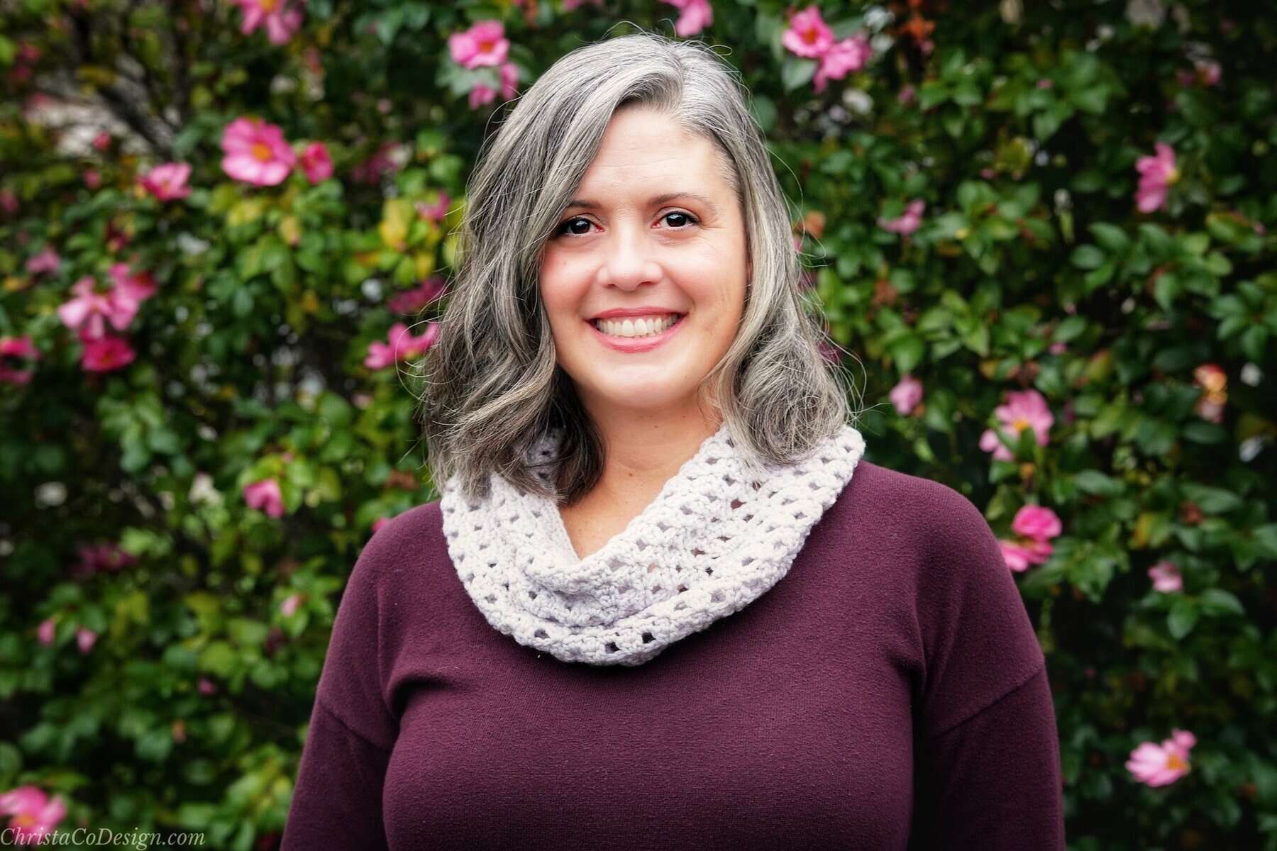 Woman smiling in white cowl.
