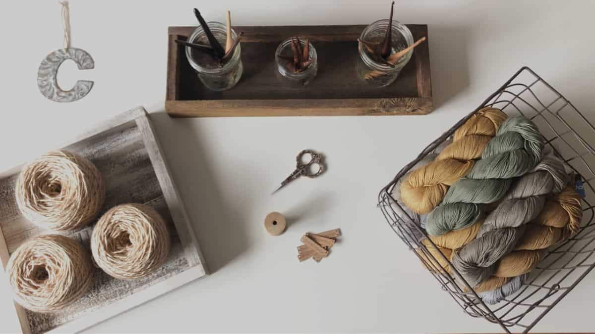 Yarn, hooks and needles on white table.