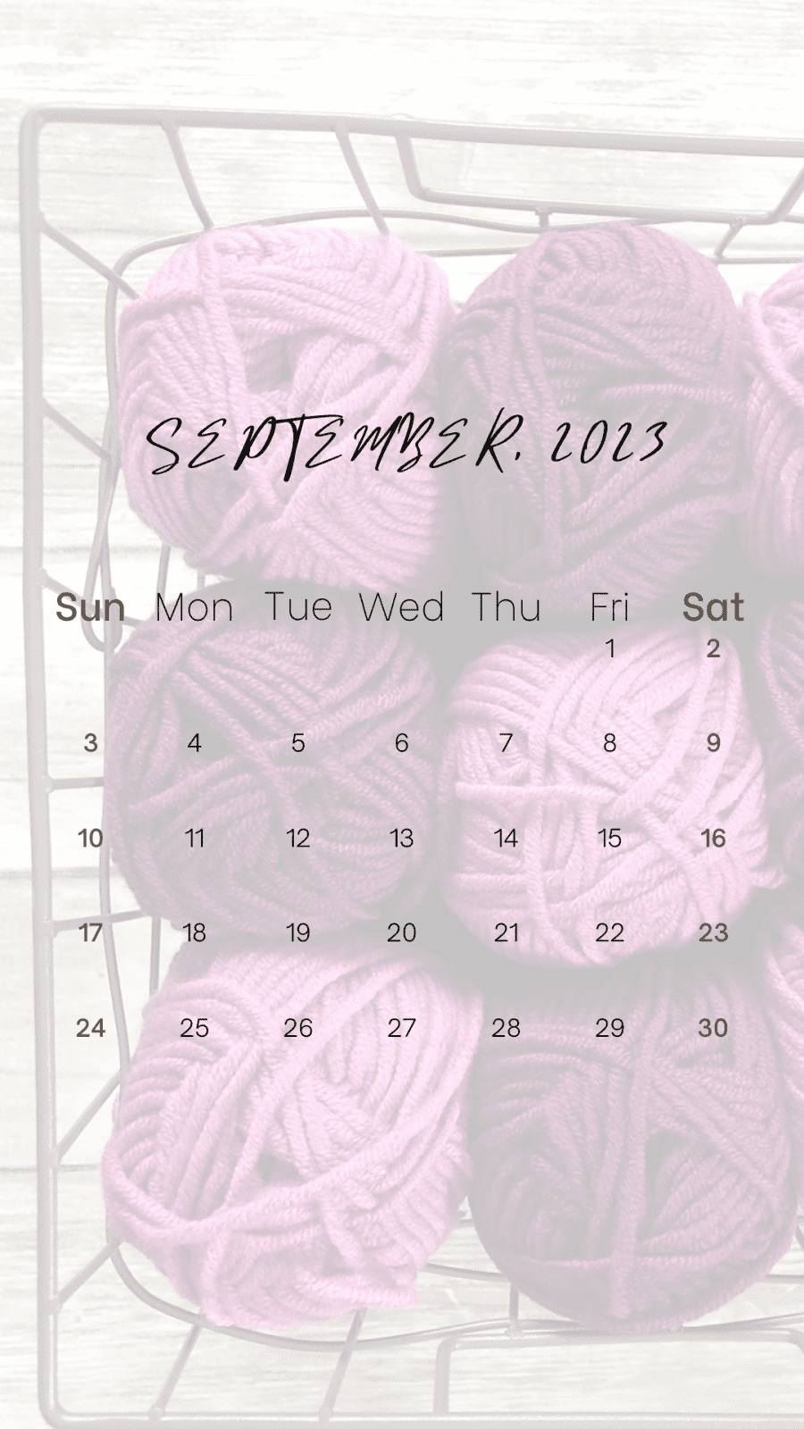 Sept 2023 calendar over pink and purple yarn balls.