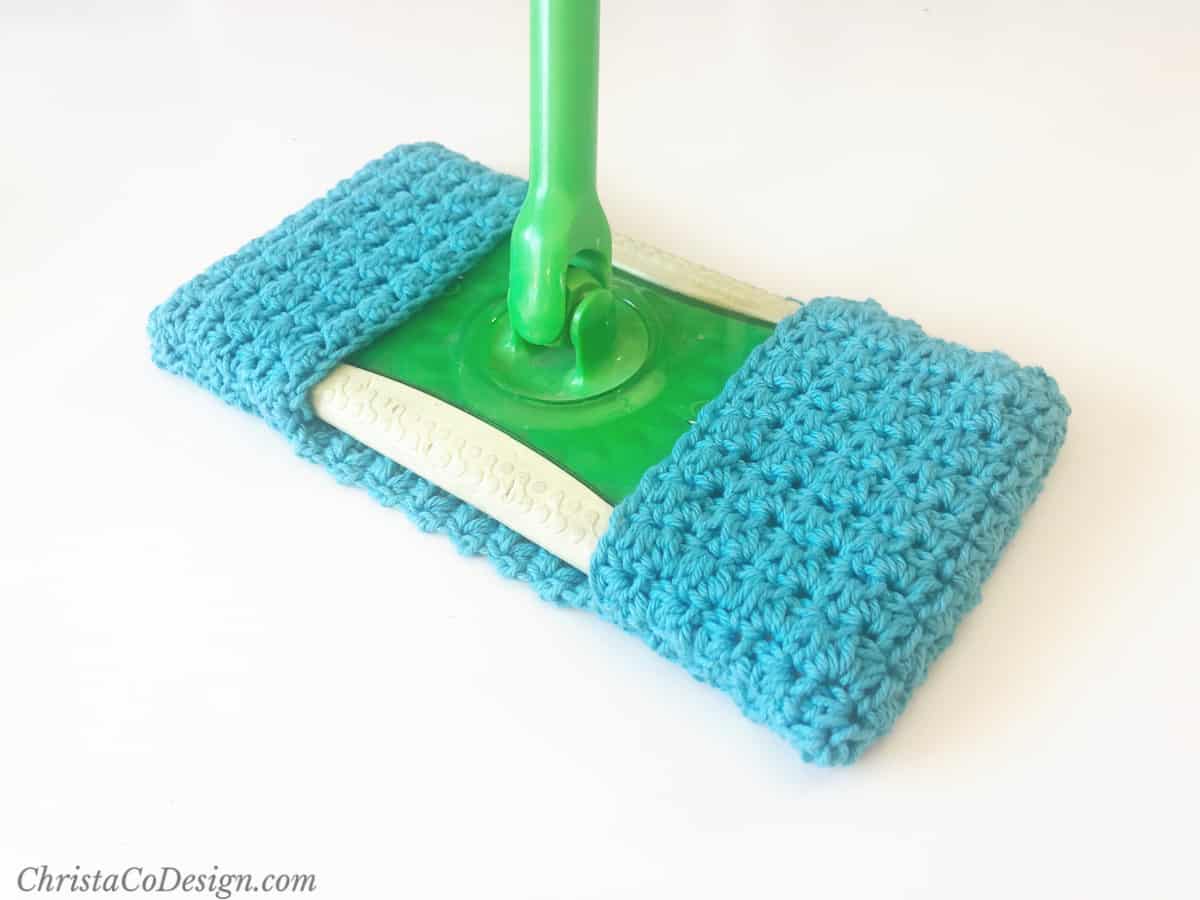 Blue crochet sweeper cover on green mop.