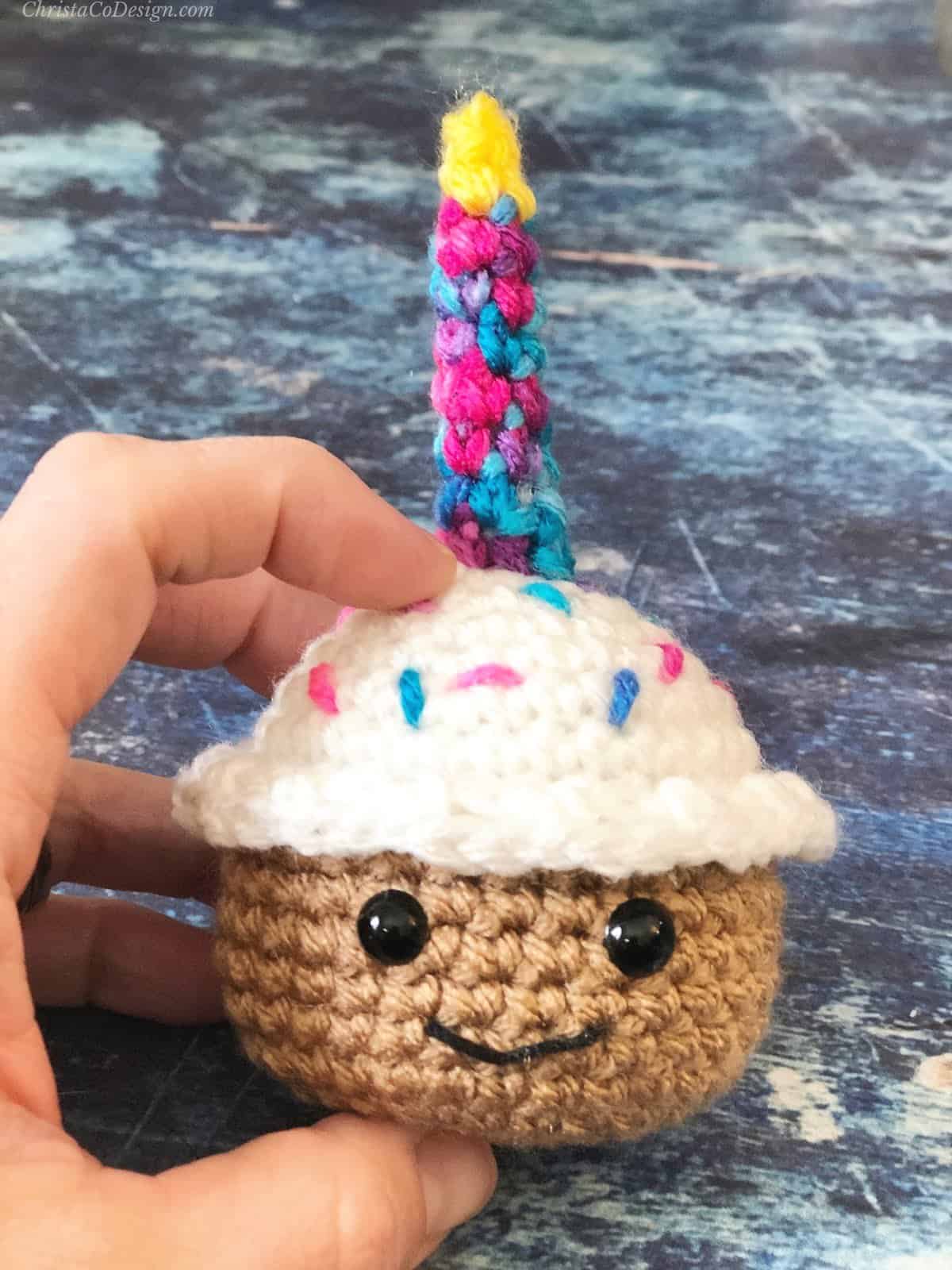 Crochet cupcake held in hand to show size.