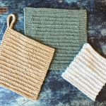 Beige, green and white knit dishcloths on blue background.