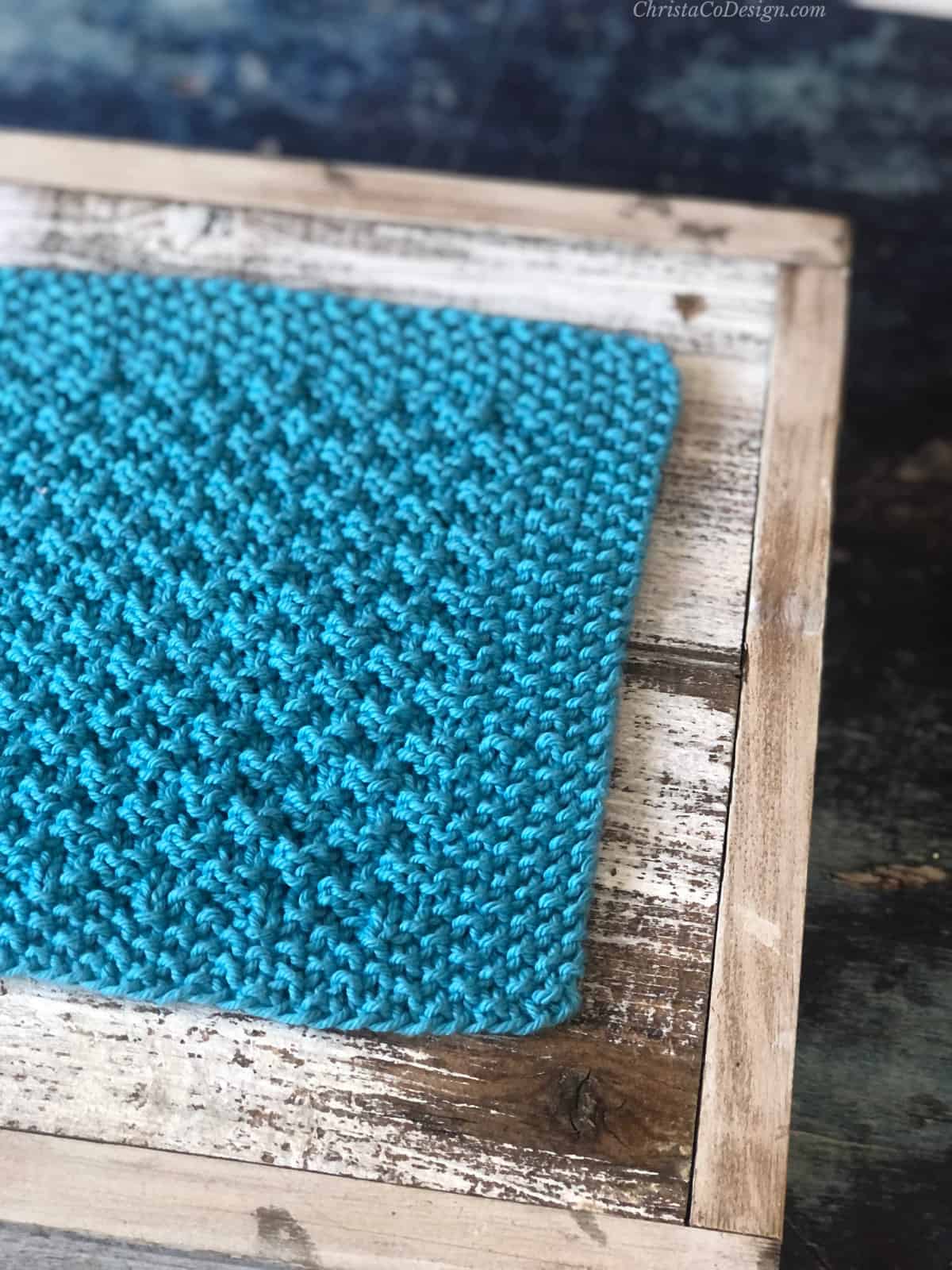 Seed stitch on border of blue knit dishcloth.