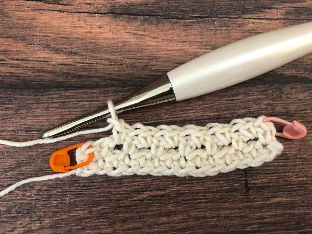 Row 3 of moss stitch on crochet hook with stitch markers in turning chains.