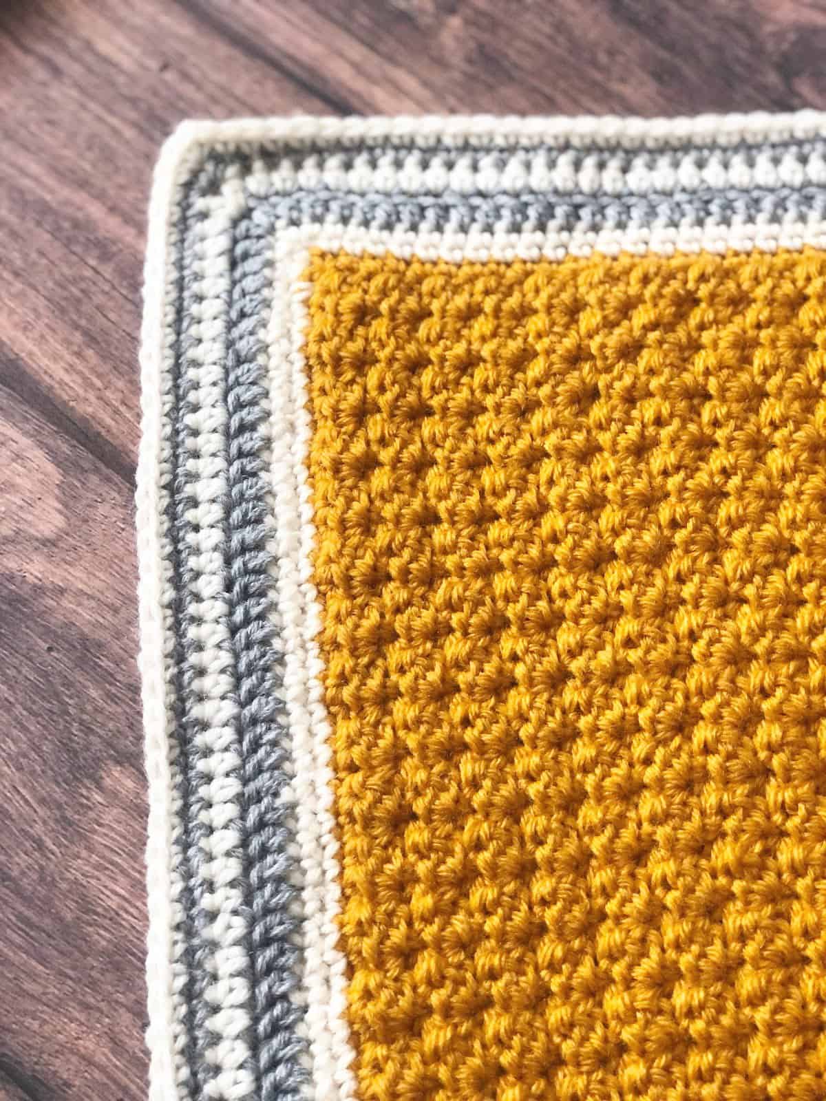 Simple striped grey and white crochet blanket border.