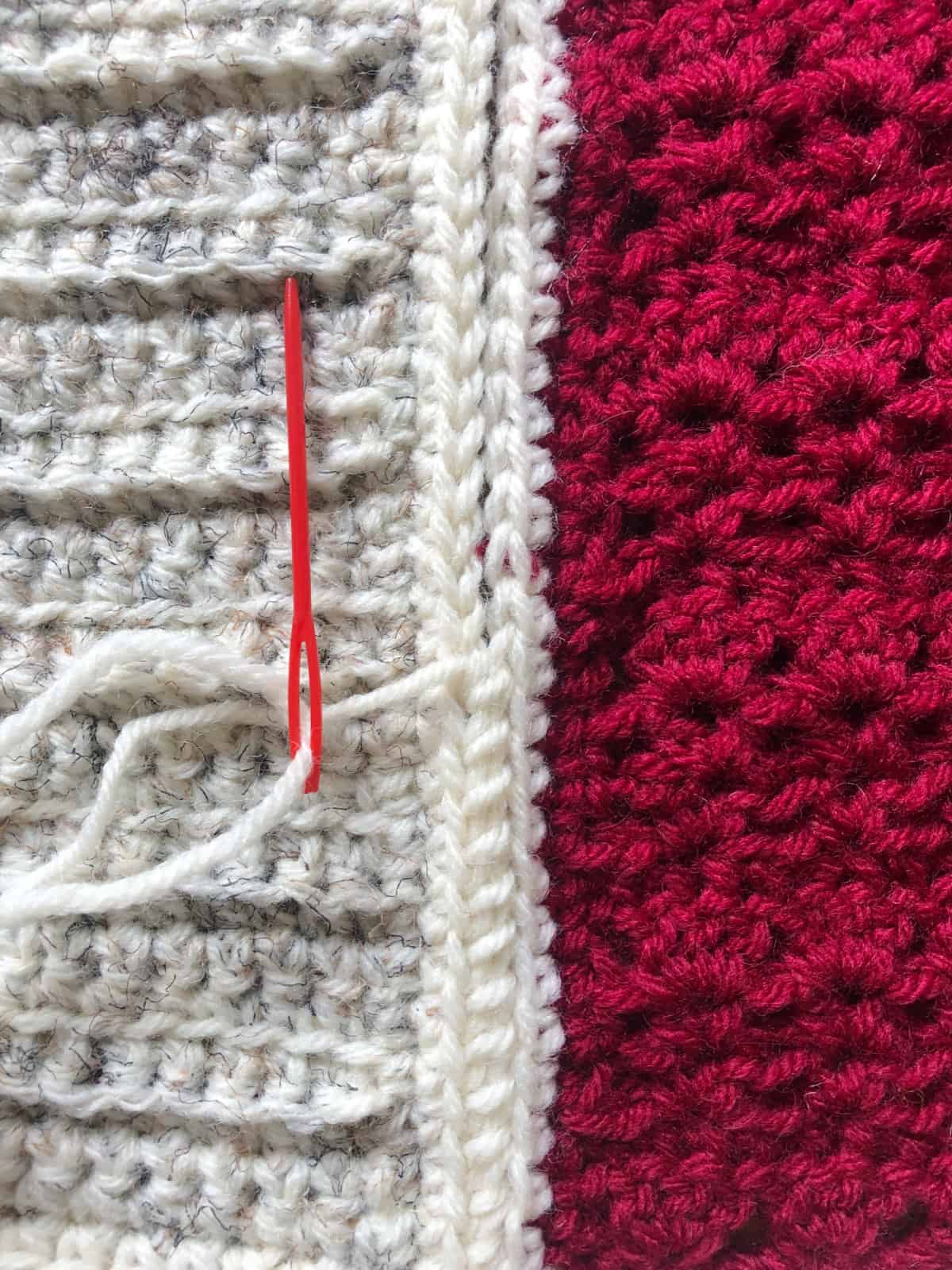 Whip stitches in white for red and white crochet squares.