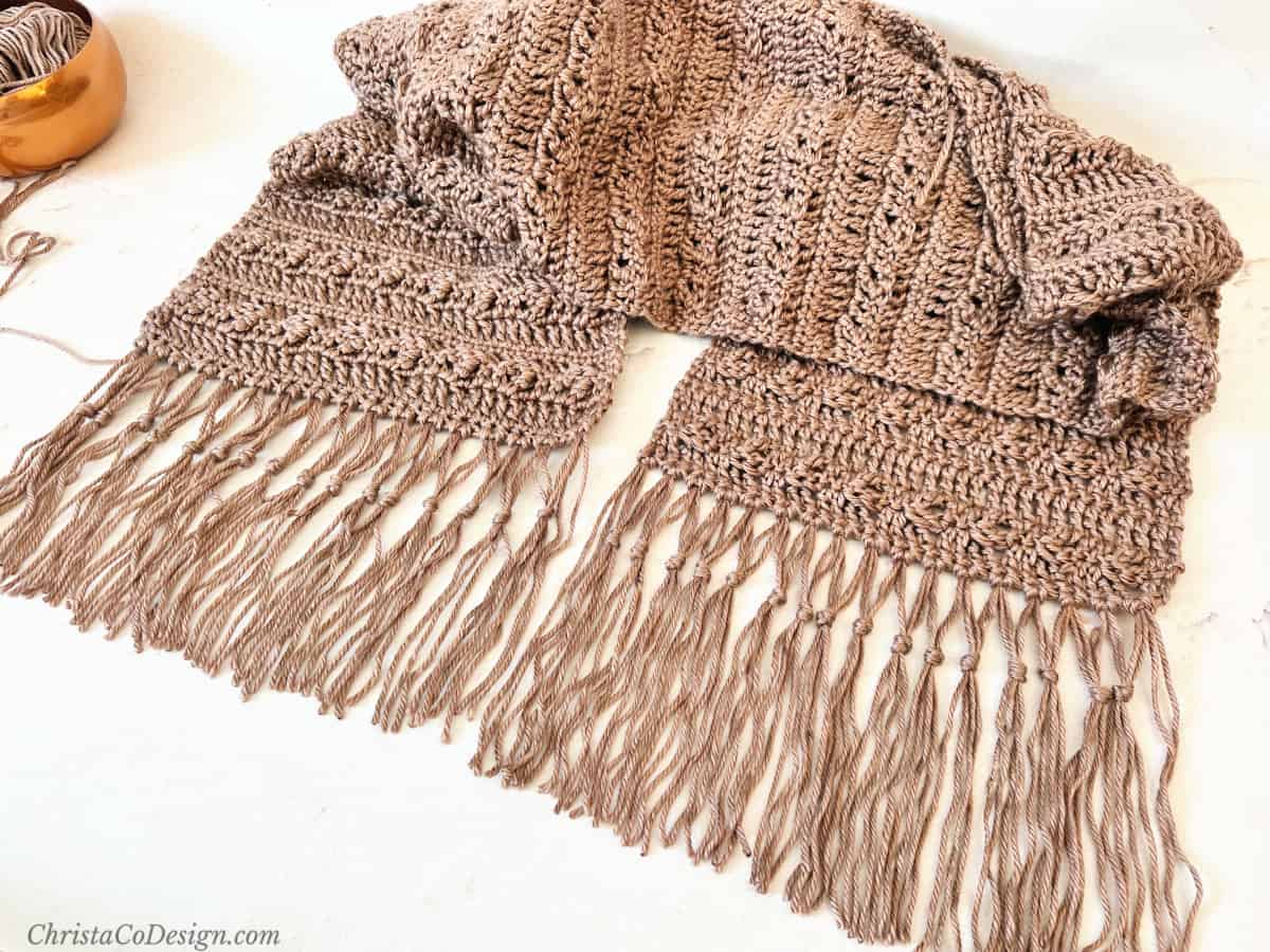 Brown scarf with double knotted fringe on both ends.