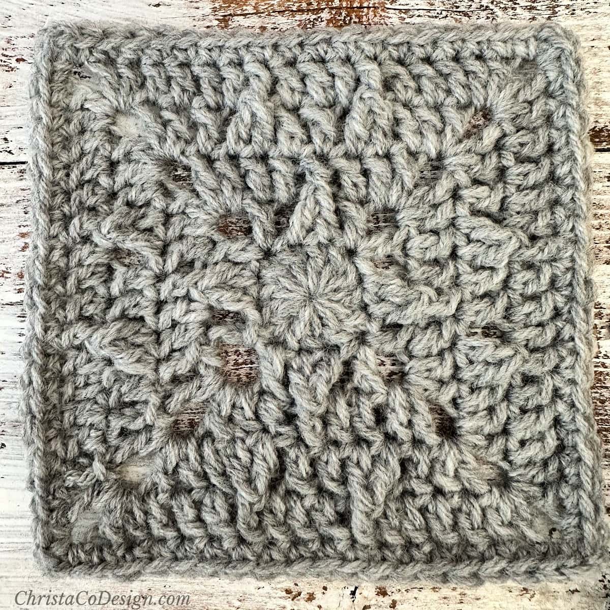 Close up of grey crochet square.