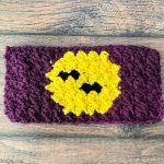 Crochet cup cozy laid flat with bats over moon.