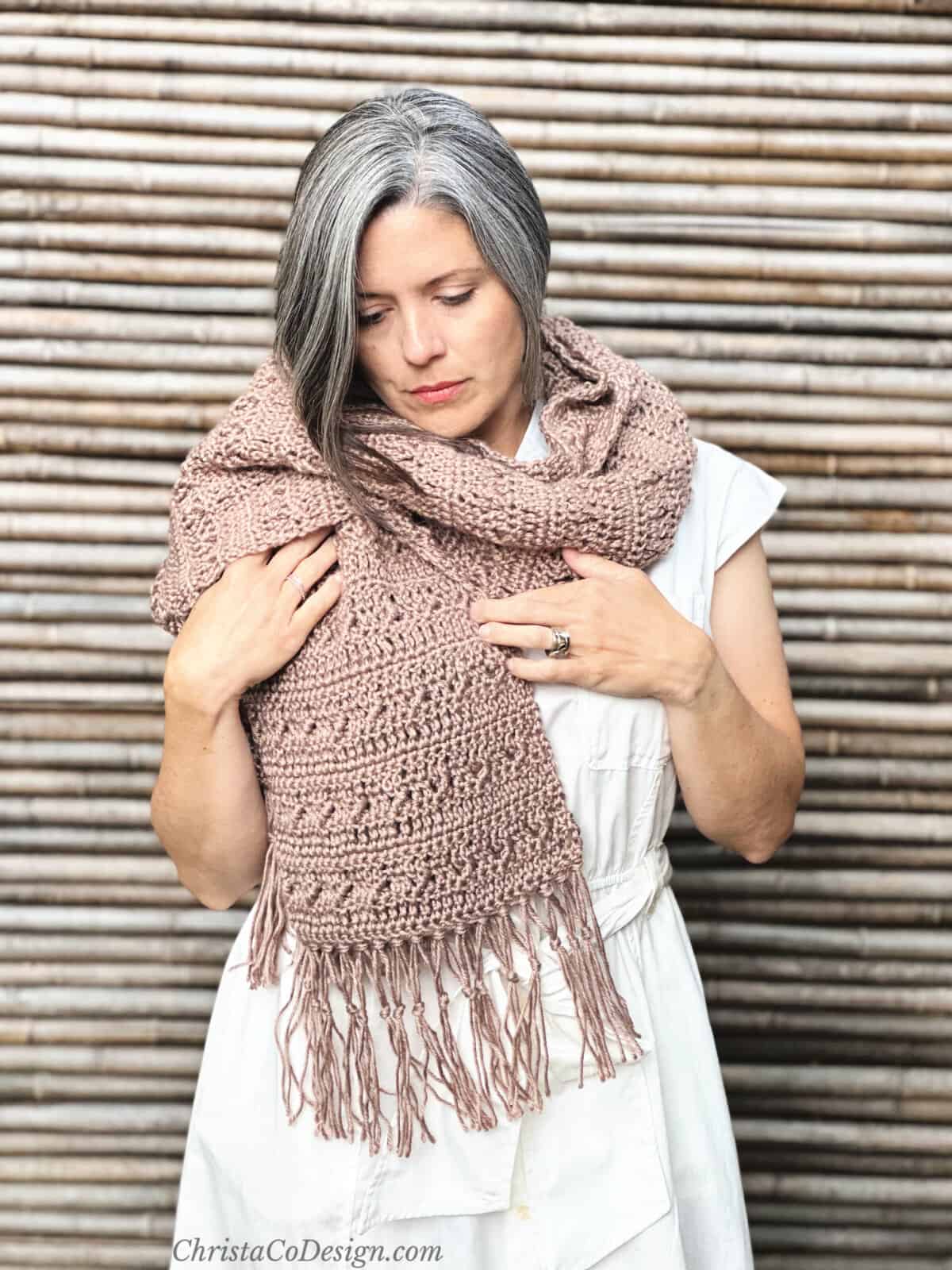 Woman in cocoa colored super scarf with fringe.