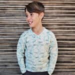 Boy in knit sweater with blue speckle.