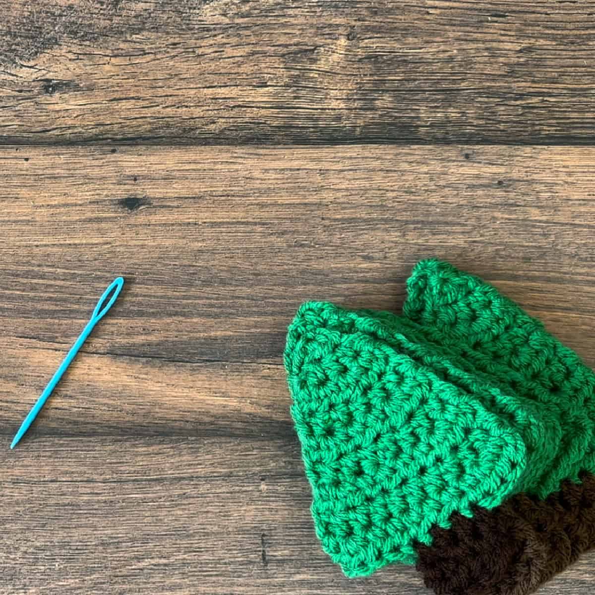Stack of crochet trees with yarn needle.