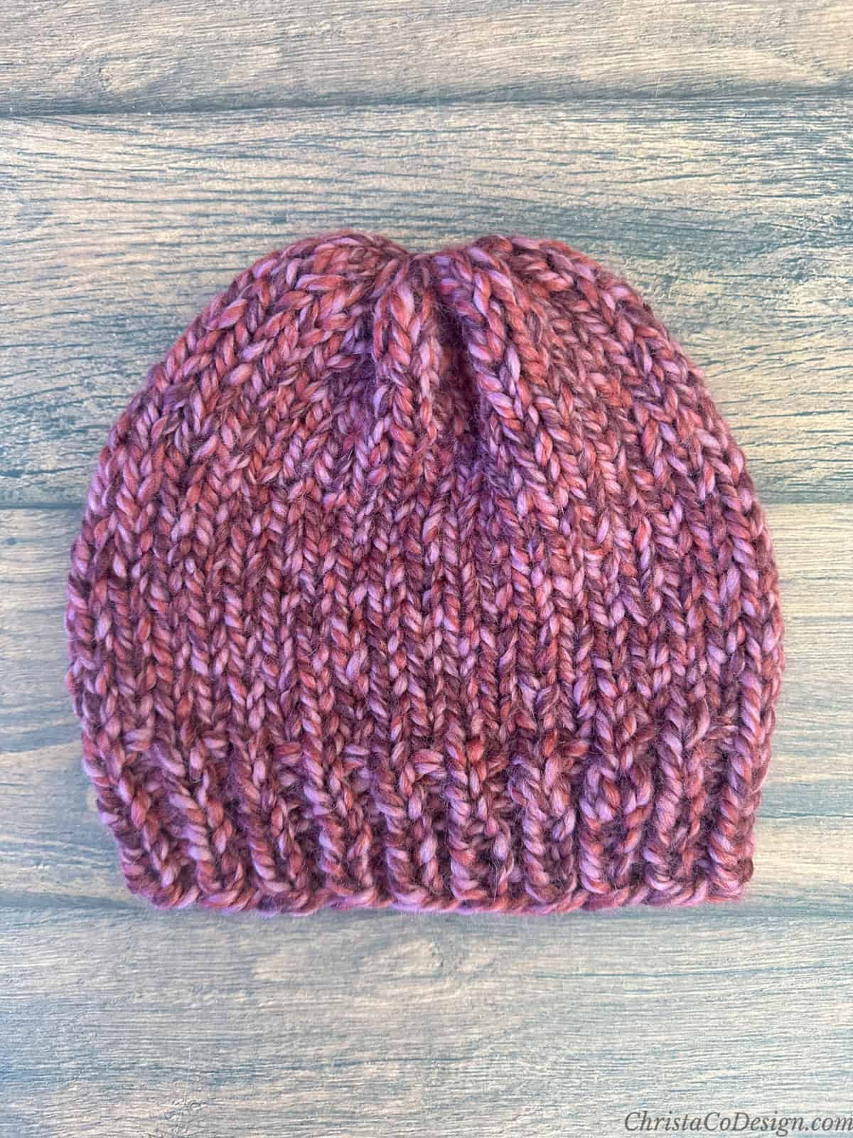 Chunky knit hat with ribbing in pink yarn.