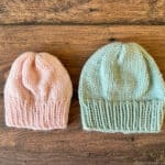 Pink and blue knit baby hats side by side.