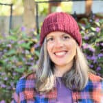 Woman in burgundy knit hat with folded brim.