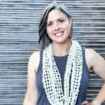 Woman smiling with mesh scarf.