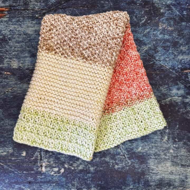 Striped knit dish towel folded over to show stripes in red, green, brown and cream.