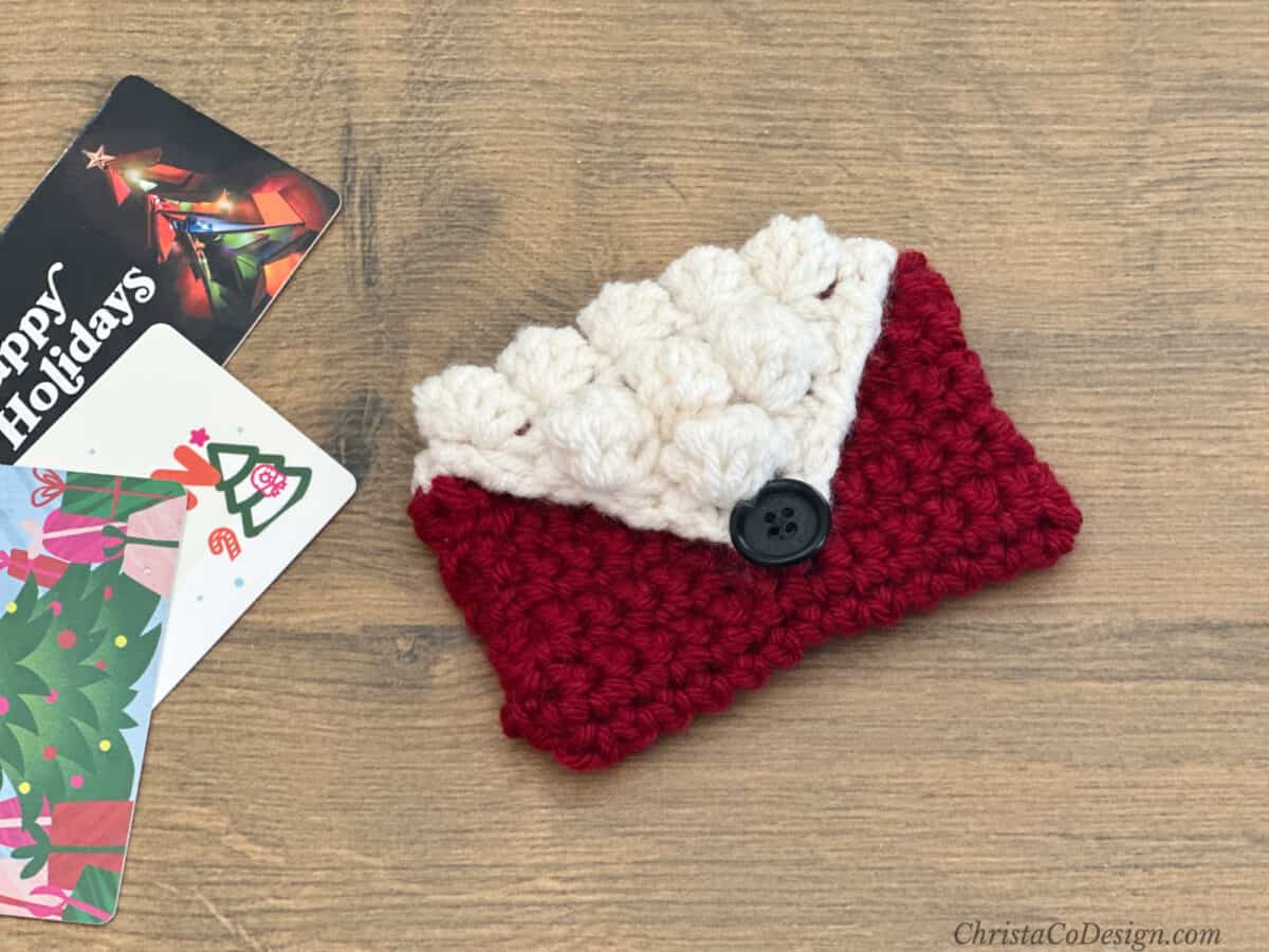 Crochet envelope in red and white next to gift cards.