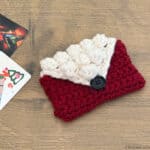 Crochet envelope in red and white next to gift cards.