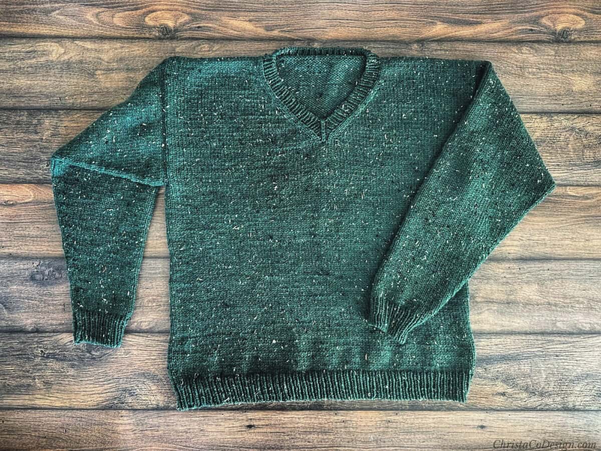 Flat lay of green knit sweater.